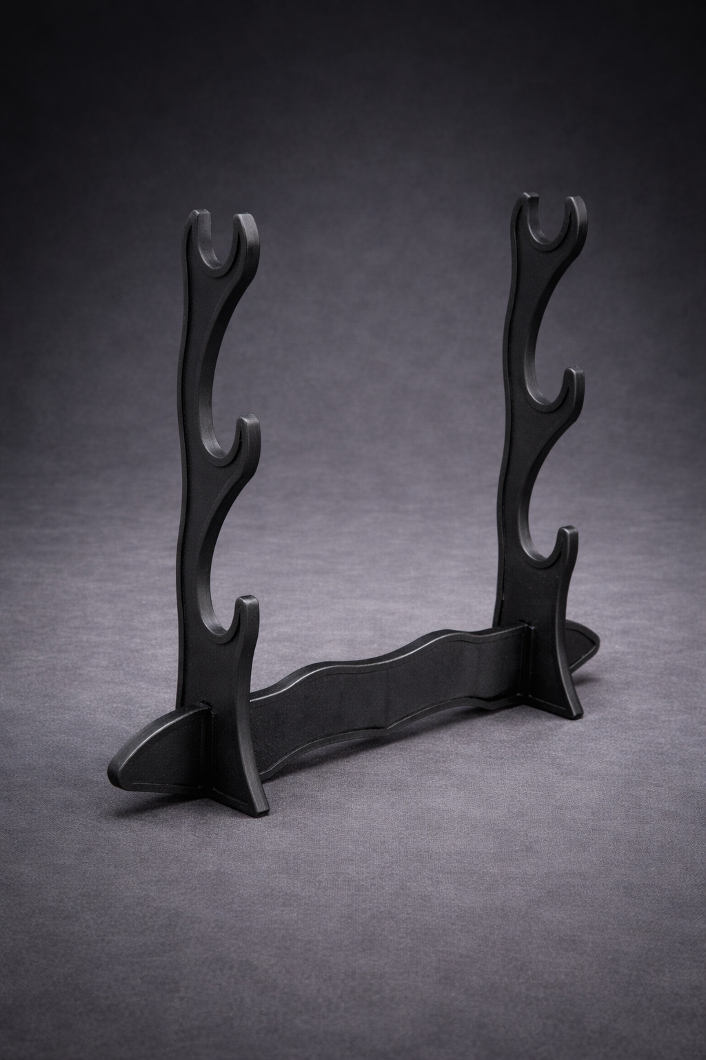 Black wooden stand with curved design on a gray background