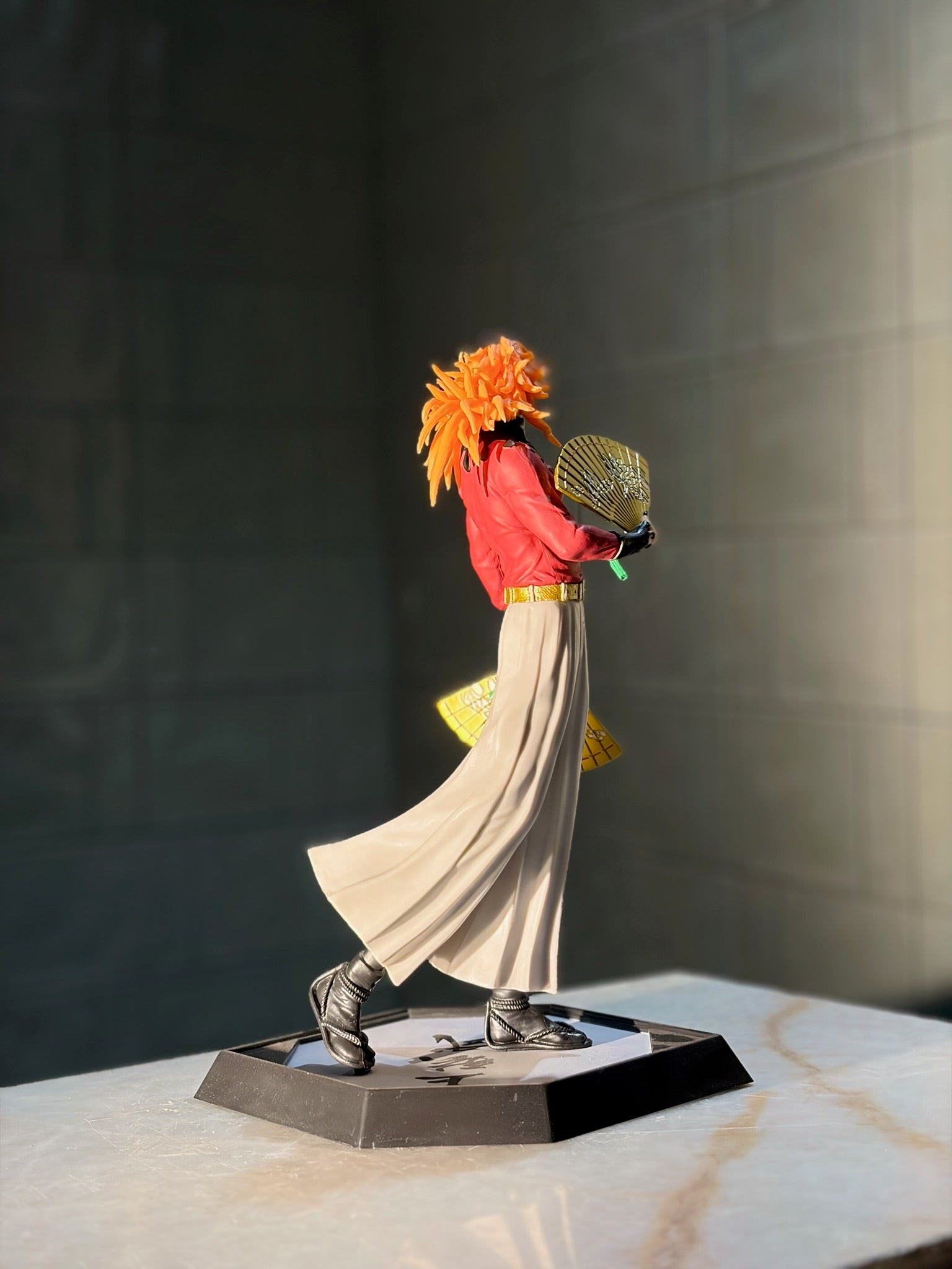 Statue of a character with orange hair and red outfit on a dark background