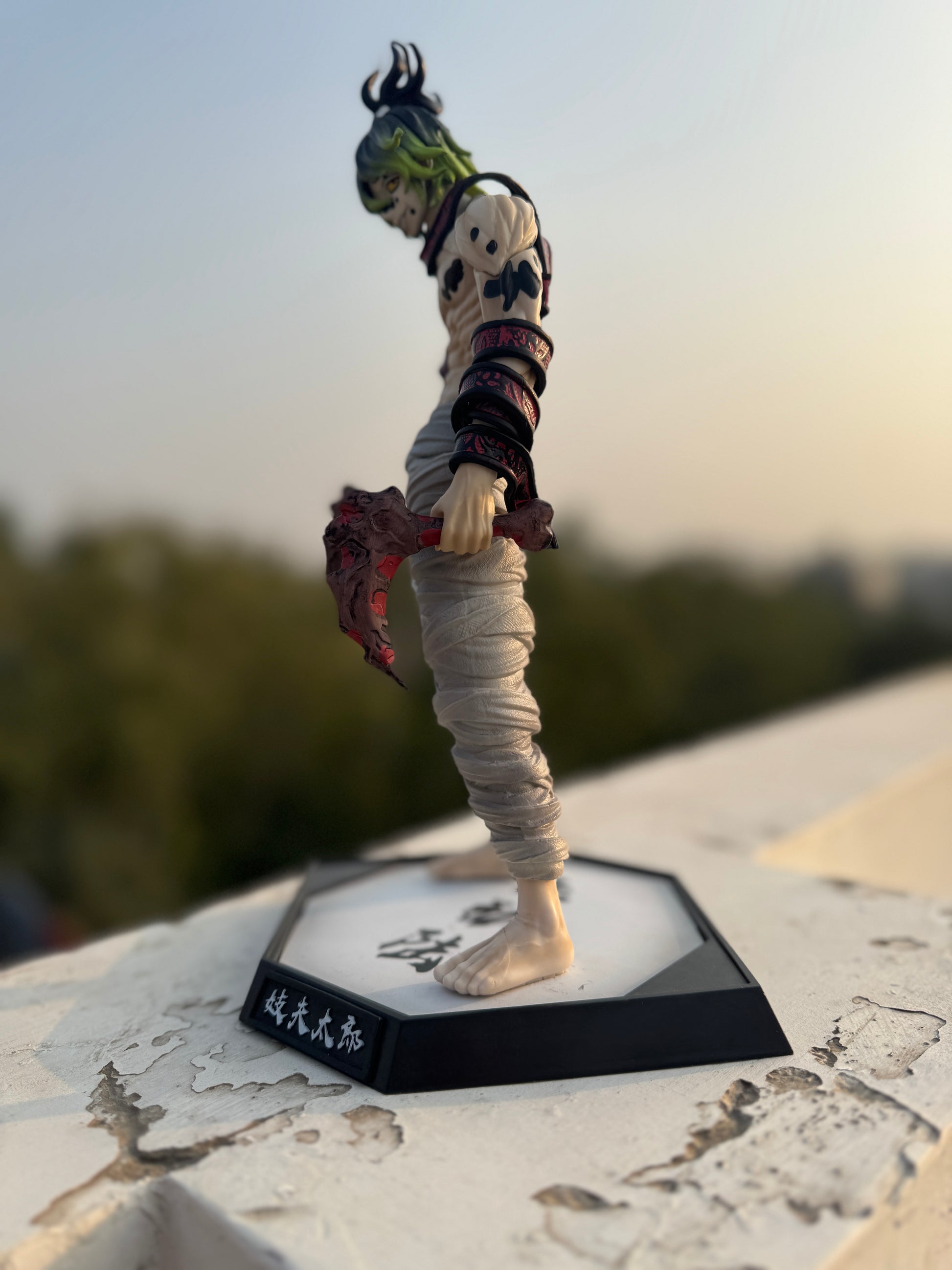 Action figure on a stand with a blurred outdoor background