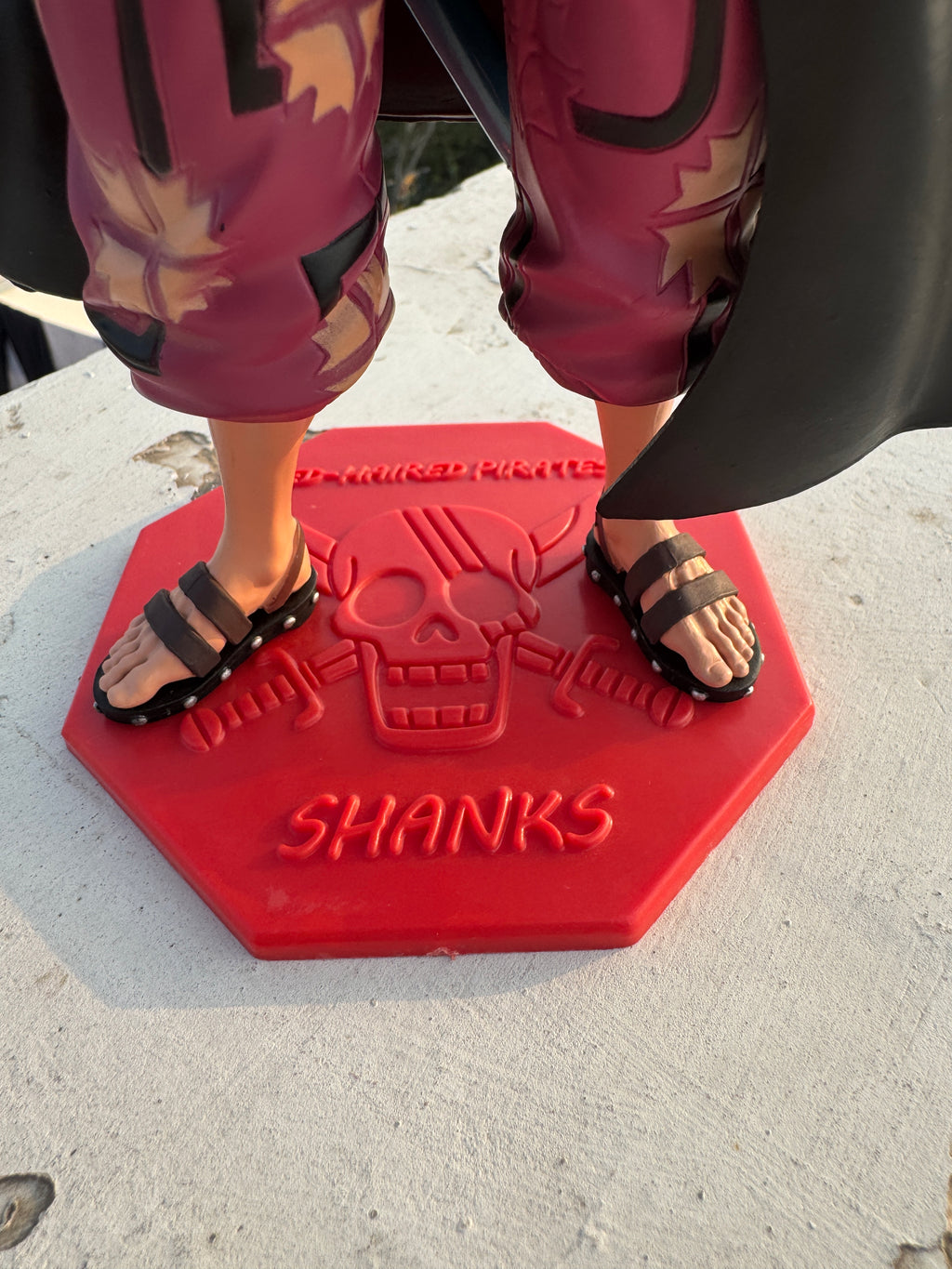 Person stepping onto a red 'Shanks' logo mat on a concrete surface