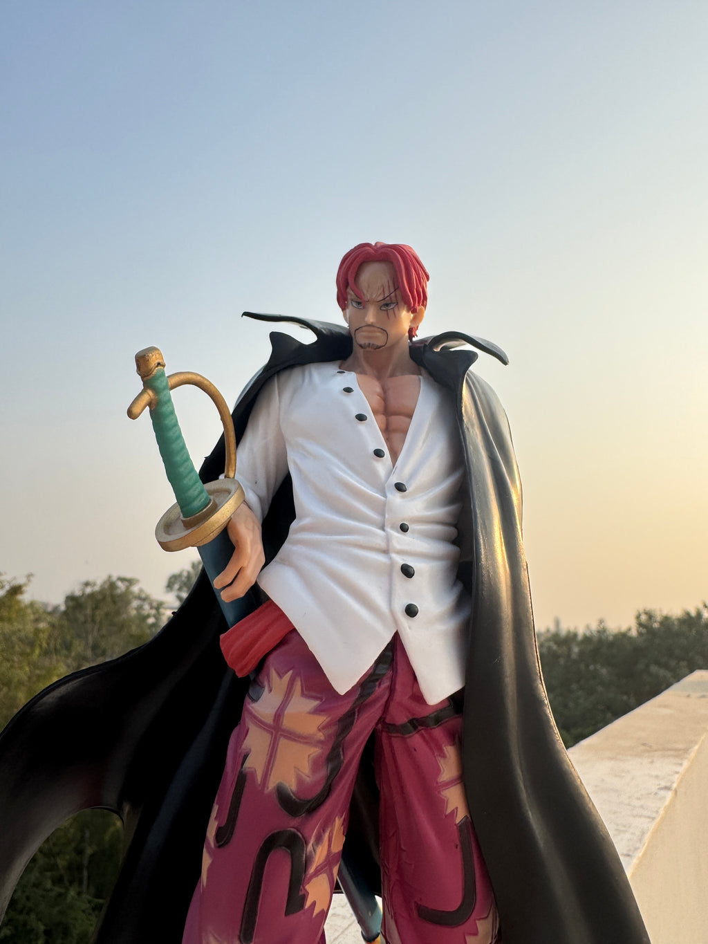 Animated character with a sword against a blurred natural background