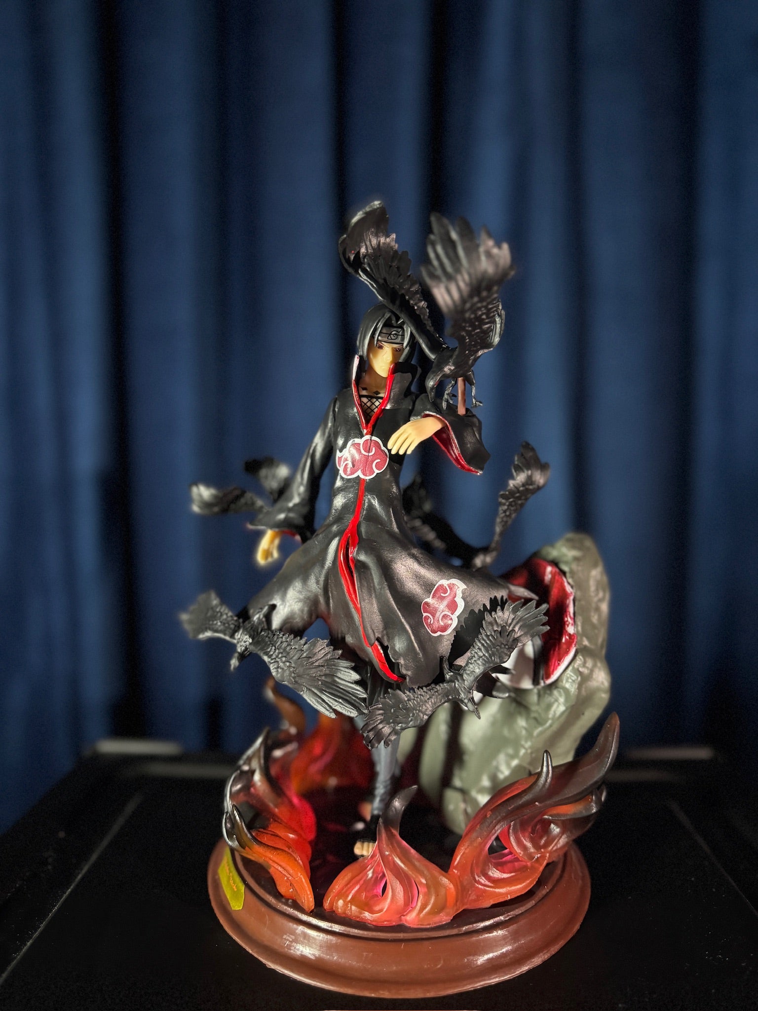 Figurine of a itachi with crows on a dark background