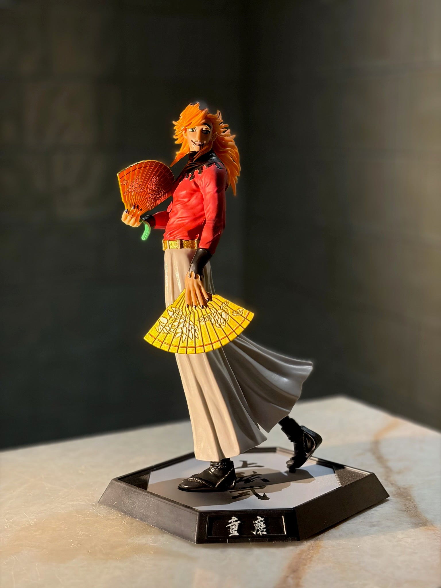 Figurine of a character with orange hair and a red and white outfit on a dark background